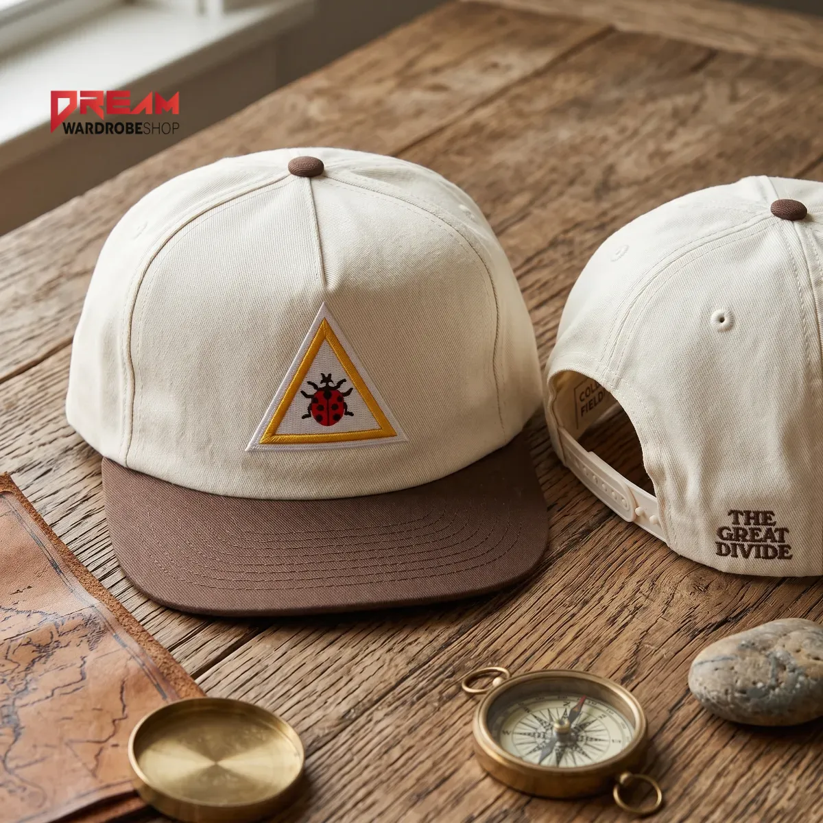 Two-tone baseball cap with ladybug embroidery on a wooden table.