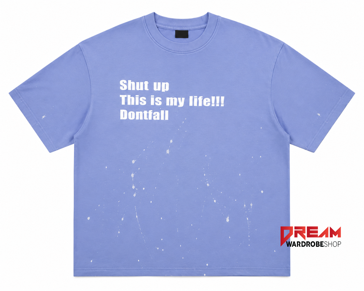 Periwinkle blue cotton baby tee featuring bold white typography and paint splatter artwork.
